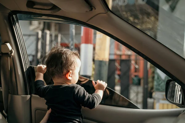 Siyah elbiseli küçük bebek pencereler açıldığında arabada durur. — Stok fotoğraf