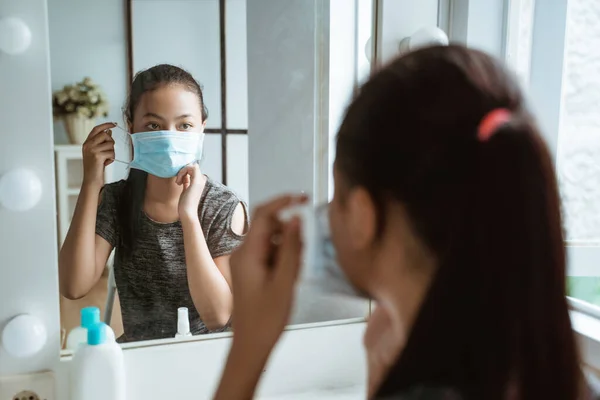 Close up of an Asian teenage girl wearing a mask while sitting before going out — Stock Photo, Image