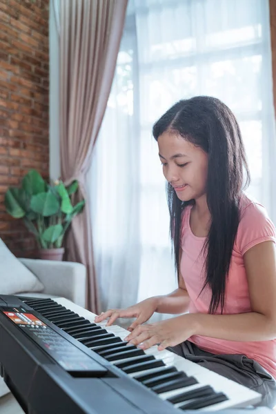 Vacker tonåring flicka sitter lära sig att spela ett piano instrument — Stockfoto