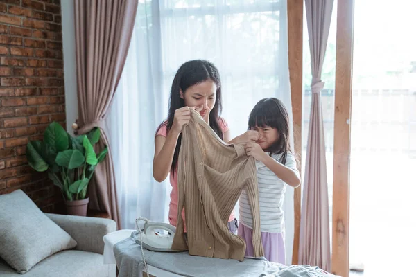 Dos hermanas cerraron la nariz con el dedo cuando sostenían una ropa de olor —  Fotos de Stock