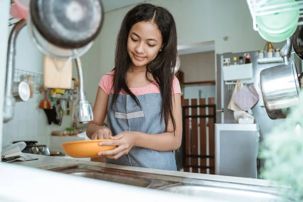 Adolescentes felizmente hacer las tareas domésticas lavar los platos — Foto de Stock
