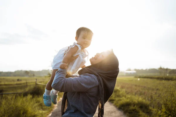 Een moeder die haar dochter opvoedt als ze midden in de rijstvelden op de weg staat — Stockfoto