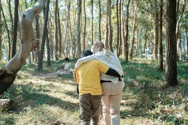 Zawoalowana matka i jej syn przytulali się, gdy odchodzili. — Zdjęcie stockowe