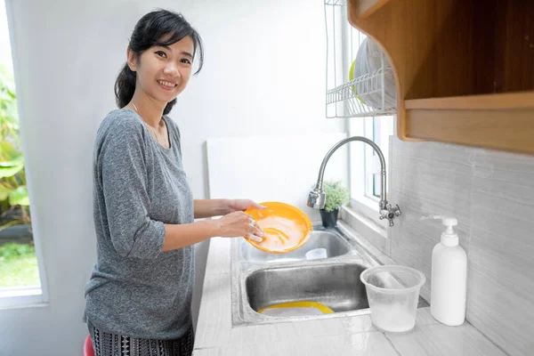 Женщина моет посуду на кухне — стоковое фото
