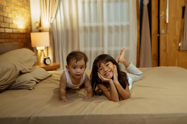 Crianças deitadas na cama em um quarto — Fotografia de Stock