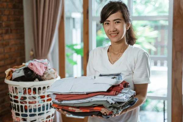 Feliz sorrindo mulher asiática carregando cesta de pano de roupa — Fotografia de Stock