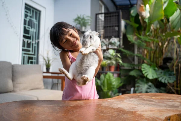 Smějící se dítě s bílým mazlíčkem králíček. — Stock fotografie