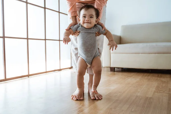 Мати допоможе своїй дитині пройти її перший крок — стокове фото