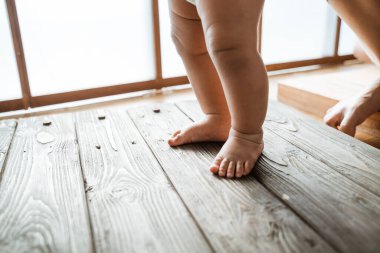 İlk adımları atan bebek ayaklarını kapat.