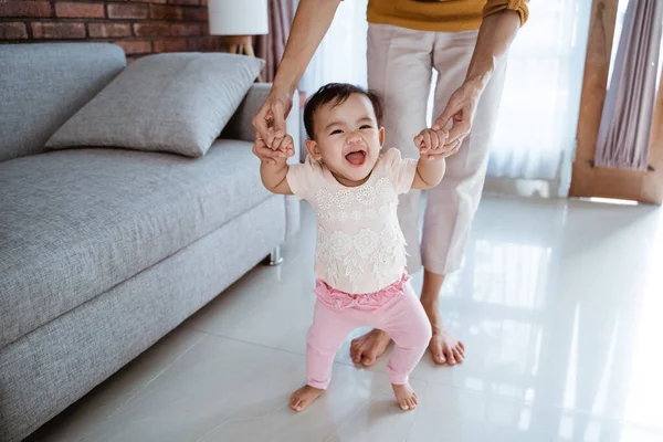 Mãe ajudar seu bebê a andar seu primeiro passo — Fotografia de Stock