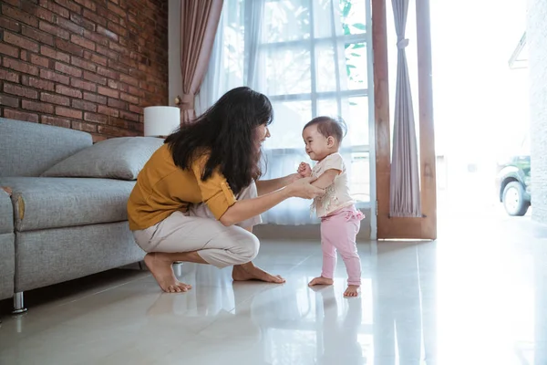 Mãe ajudar seu bebê a andar seu primeiro passo — Fotografia de Stock