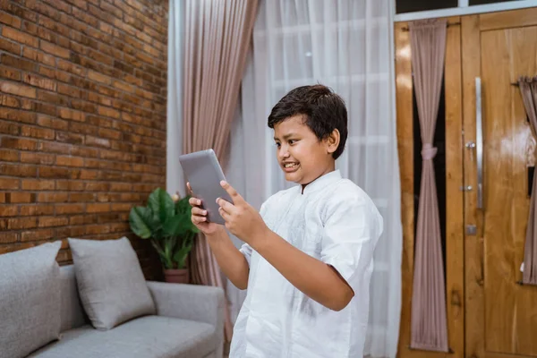 The boy is tensed while playing games on the digital tablet — Stock Photo, Image