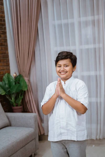 Asiatico ragazzo indossa un koko camicia stretta la sua mani dire salaam — Foto Stock