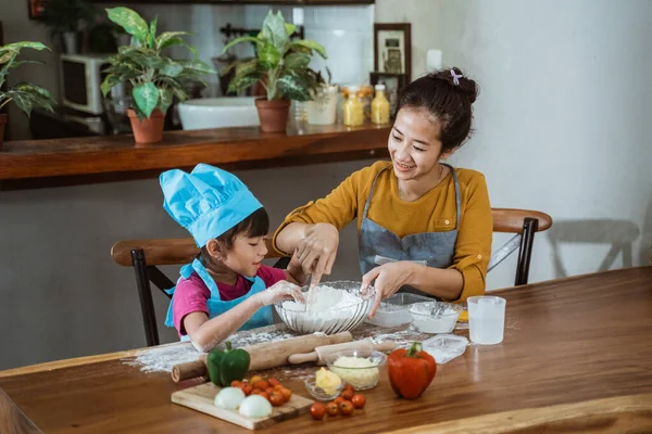Ibu dan daugthter memiliki menyenangkan memasak bersama-sama dan belajar untuk membuat kue — Stok Foto