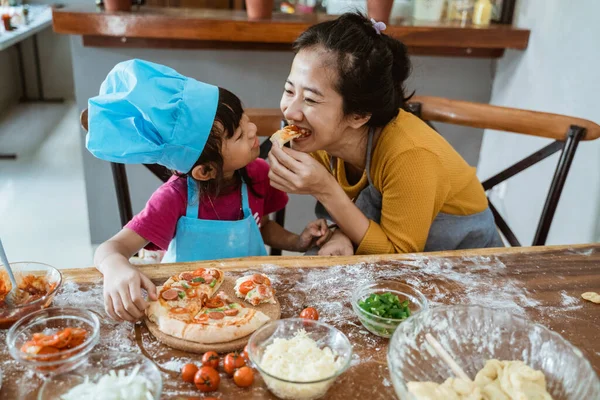 Ibu muda dan putrinya makan pizza — Stok Foto