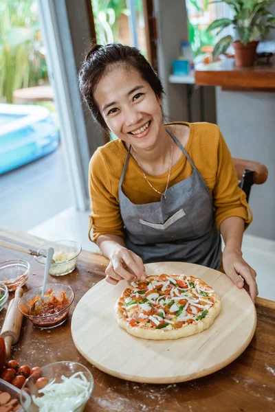 Oung женские руки делают пиццу дома — стоковое фото