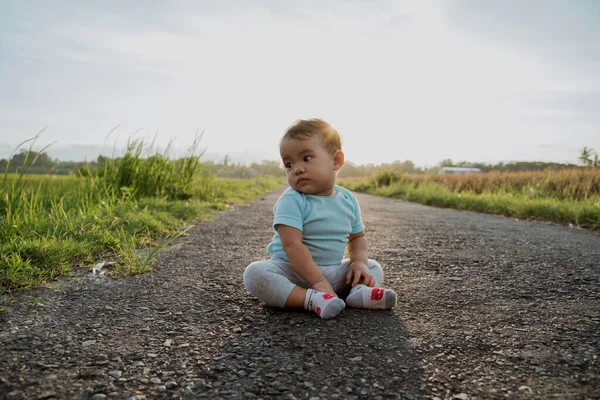 可愛いアジアの赤ちゃん一人で空の道に座って — ストック写真