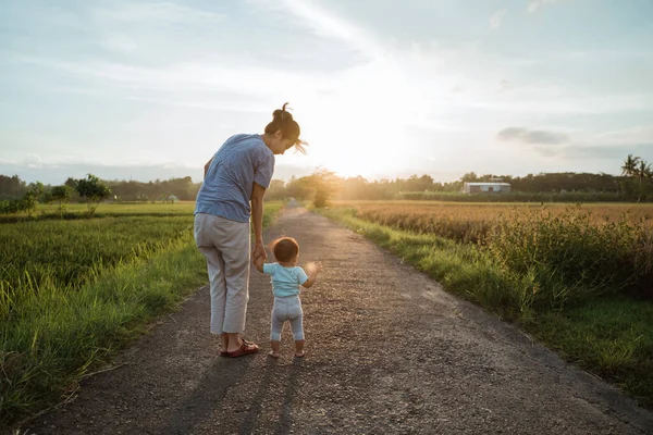 Matka pomoci její dítě chodit její první krok — Stock fotografie