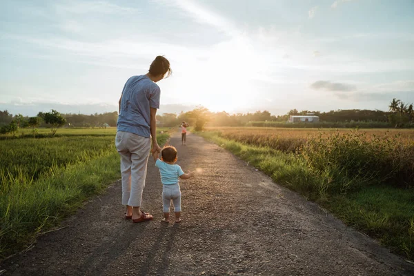 Madre ayudar a su bebé a caminar su primer paso — Foto de Stock