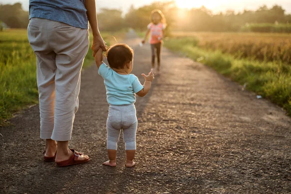 Anya segít neki, hogy a baba járni az első lépést — Stock Fotó