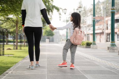 Anneler sabah kızlarını okula götürür.