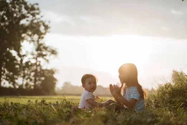Starší sestra si hraje se svou mladší sestrou na polích — Stock fotografie