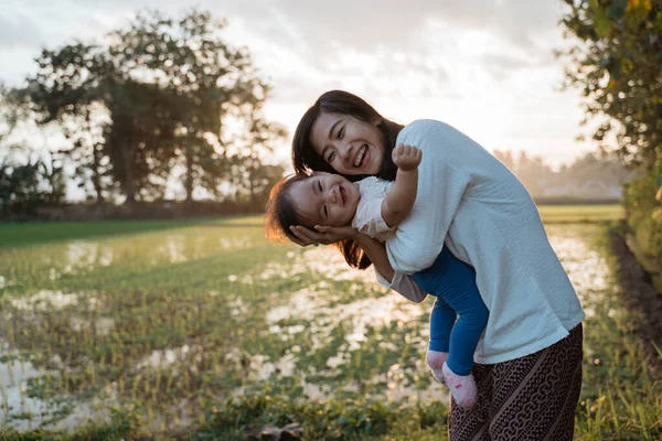 A portrait of a happy mother hugging her child in the rice fields — Stock Photo, Image