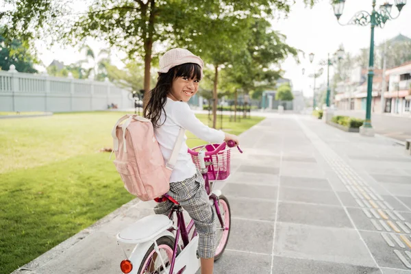 Menina andar de bicicleta no parque indo para a escola sozinha — Fotografia de Stock