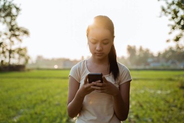 Elinde cep telefonu olan güzel bir kızın portresi.