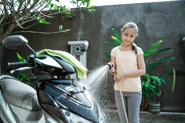 एशियन युवा मुलगी पाणी त्याच्या मोटारसायकल स्कूटर धुणे — स्टॉक फोटो, इमेज