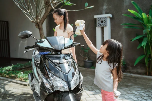 Potrait menina feliz e menina pequena motocicleta de lavagem — Fotografia de Stock