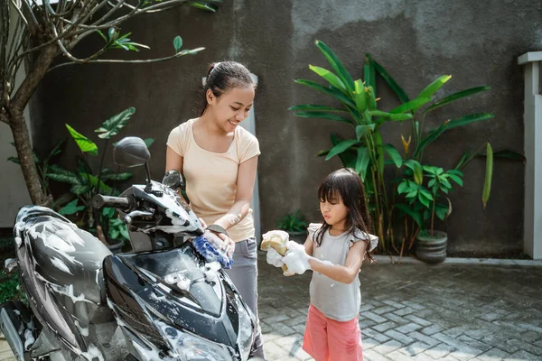 Potrait heureux jeune fille et petite fille lavage moto — Photo