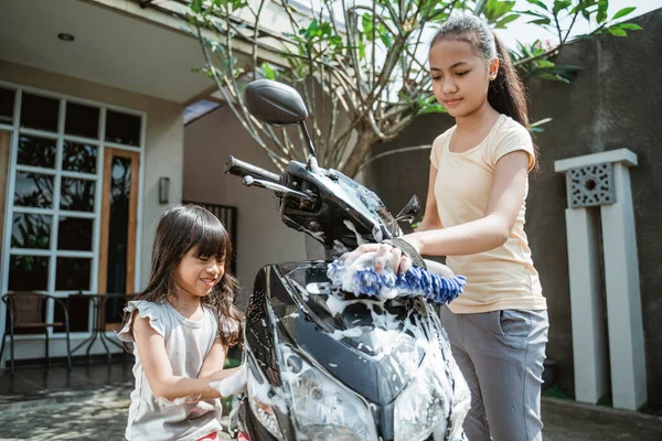 Potrait heureux jeune fille et petite fille lavage moto — Photo