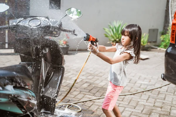 Asiático menina lavar sua moto scooter com água — Fotografia de Stock