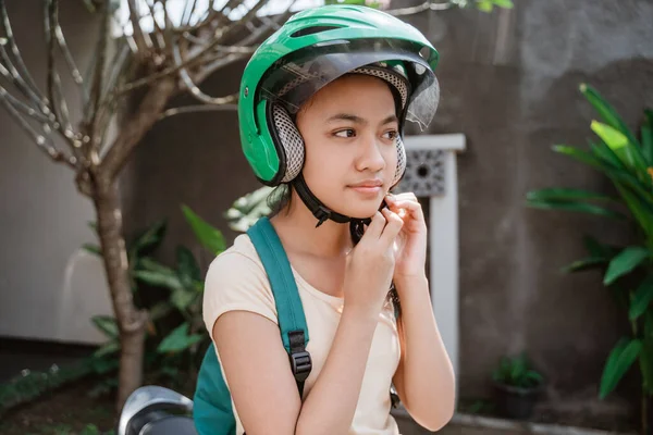 Adolescente menina fechar enquanto vestindo e prender seu capacete de motocicleta — Fotografia de Stock