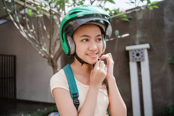 Tizenéves lány közelről, miközben visel, és rögzítse a motorkerékpár sisak — Stock Fotó