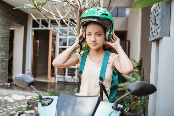 Krásná mladá dívka sedí na jeho motocyklu nosí tašku a helmu — Stock fotografie
