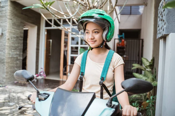 Belle jeune fille est assise sur sa moto portant un sac de t-shirt et un casque — Photo