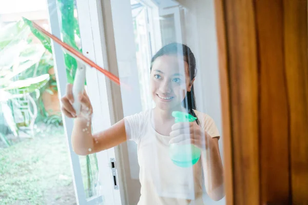 Adolescente chica lava una ventana — Foto de Stock