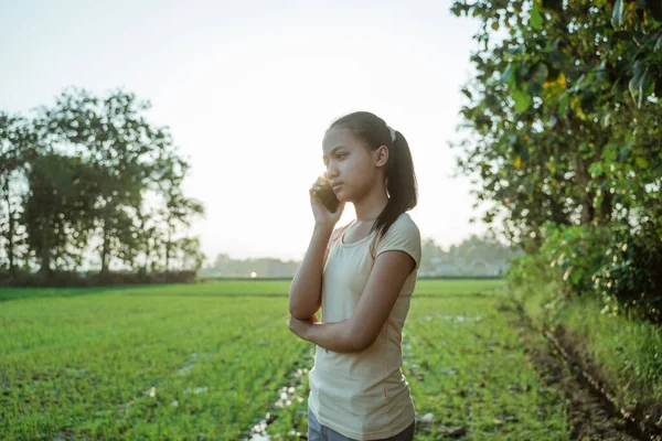 Portré egy gyönyörű fiatal lány néz, miközben a kezében egy mobiltelefon — Stock Fotó
