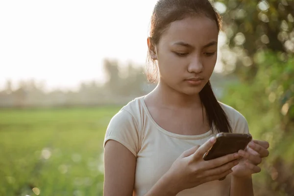 Porträt eines traurigen jungen Mädchens, das ein Handy in der Hand hält — Stockfoto