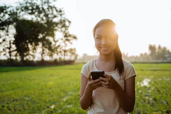 Porträt eines schönen jungen Mädchens, das in der Hand eines Mobiltelefons schaut — Stockfoto