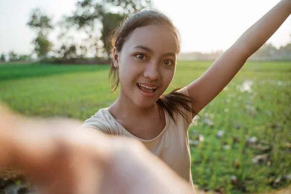 Portrét krásné mladé dívky při držení mobilu vzít selfie — Stock fotografie