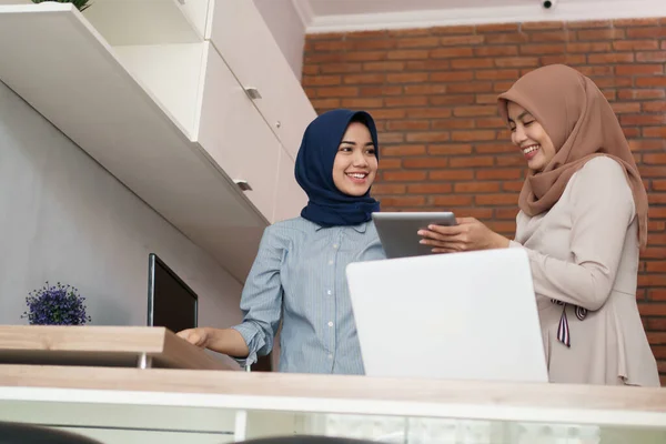 Retrato de hermosas mujeres musulmanas explicando proyecto en tableta a su pareja — Foto de Stock