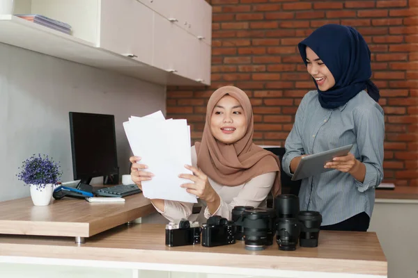 Porträt schöner muslimischer Frauen lächelt, während sie ihrem Partner Projekt auf Papier erklärt — Stockfoto