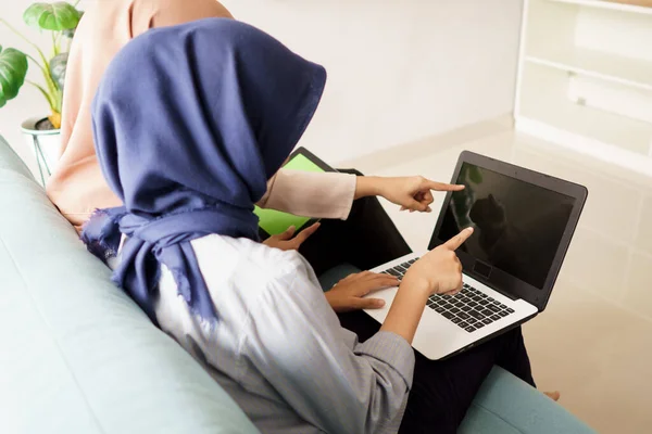Ritratto di belle donne musulmane che spiegano il progetto sul computer portatile al suo partner — Foto Stock