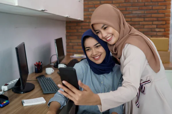 Un retrato de una hermosa mujer musulmana que es muy feliz con su pareja y selfie mientras trabaja — Foto de Stock