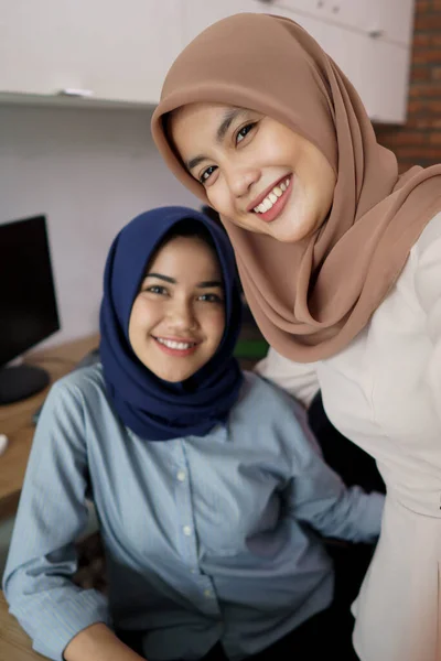 A portrait of a beautiful Muslim woman who is very happy with her partner and selfie while working — Stock Photo, Image