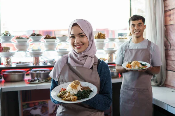 做传统食品销售员的年轻男子和穆斯林妇女的肖像 — 图库照片