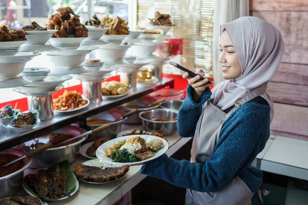 Retrato de jovem muçulmano mulher tirar fotos de comida — Fotografia de Stock